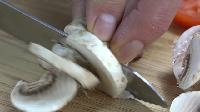 Closeup of a button mushroom being sliced
