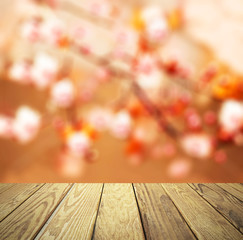 Naklejka na ściany i meble Empty wood table over blurred flowers with bokeh background, product display template,deck,