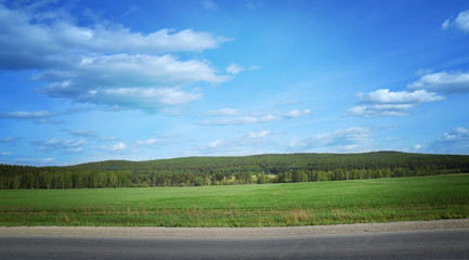 Landscape with road, forest, river and blue sky