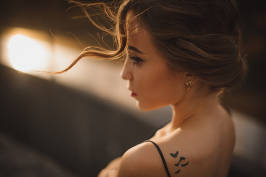 beautiful girl profile with tattoo on shoulder , soft focus