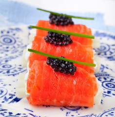 Smoked salmon rolls with cream cheese, black caviar