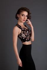Naklejka premium beautiful girl in black skirt model posing on a black background