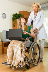 Social worker and invalid with laptop