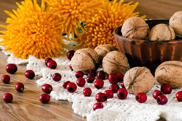 Walnuts in a bowl and hawthorn on the table