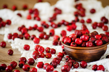Hawthorn berries in the bowl and scattered on the table