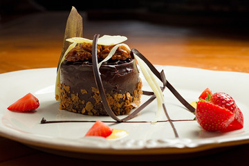 Beautiful dessert: chocolate cake with nuts on a plate close-up. horizontal