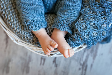 Close up picture of new born baby feet in knitted plaid
