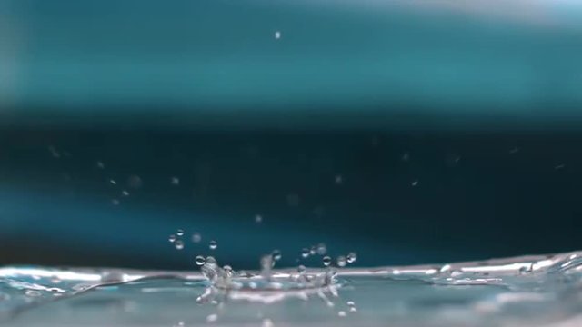 Macro of Water Droplet Falling on a Glass Bottle in Slow Motion 1000 fps with Blue Background