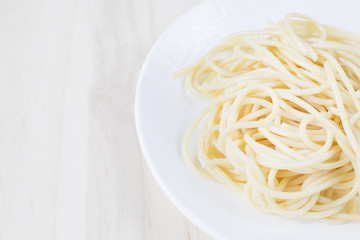 Spaghetti on white dish on wooden background