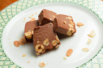 Chocolate-almond pieces with nuts on plate