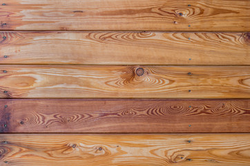 Larch wooden planks on the building facade covered with preventive impregnation