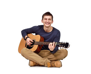 man with guitar sitting on floor