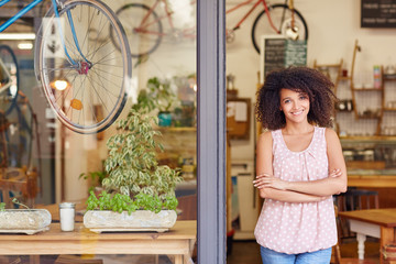 Coffee shop owner standing proudly in the door of her cafe