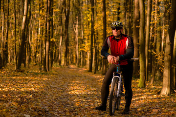 Fototapeta na wymiar Biker on the forest road riding outdoor