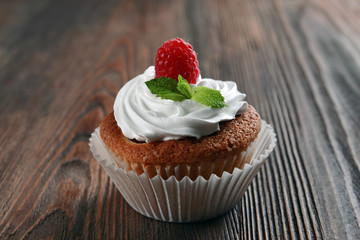 Delicious cupcake with berries and fresh mint on wooden table close up