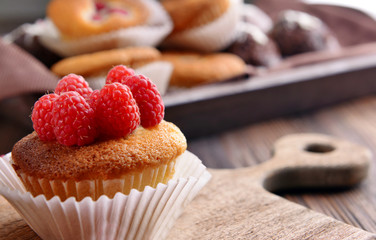 Delicious cupcakes with berries and fresh mint on wooden table close up