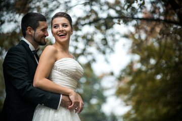 groom embracing bride from back