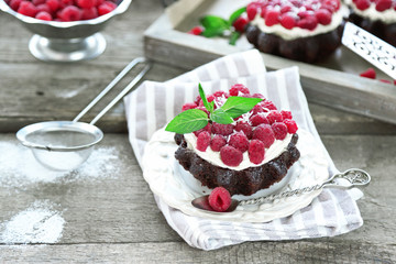 Sweet cakes with raspberries on wooden table background
