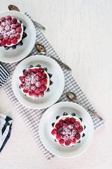 Sweet cakes with raspberries on light wooden background