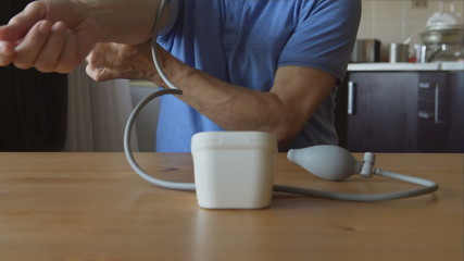 The hands of an aged man measuring the blood pressure at home