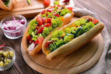 Hot dogs and vegetables on wooden cutting board