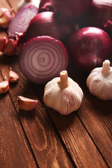 Fresh red onions with garlic on wooden background
