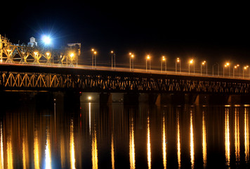 Beautiful  railway bridge,2 tiers. in the evening, lanterns are reflected in water.