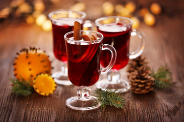 Mulled wine with orange on wooden table
