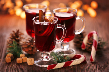 Mulled wine with candies on wooden table