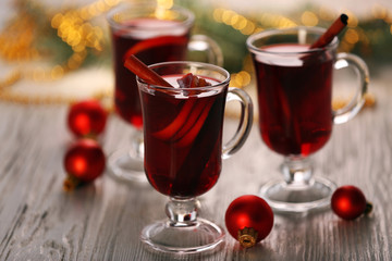 Mulled wine with red Christmas toys on wooden table