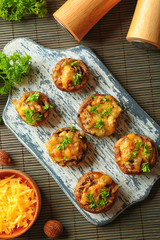 Stuffed mushrooms on wooden board, on table background
