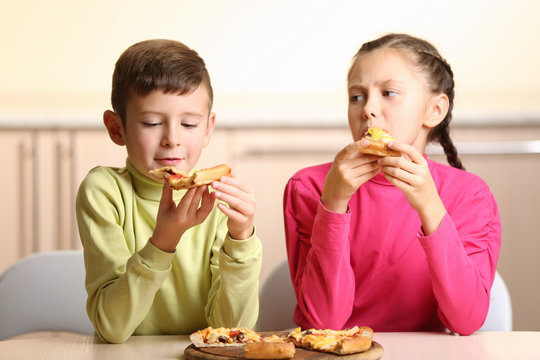 Children eating pizza at home