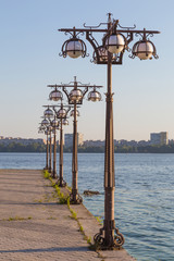 Metal forged lights on  promenade of  river.
