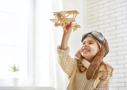 girl playing with toy airplane