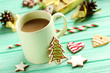 Gingerbread cookies with cup of hot coffee on a mint wooden tabl