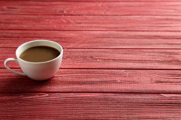 Cup of coffee on a red wooden table