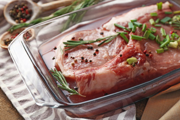 Marinating meat with spices on wooden table
