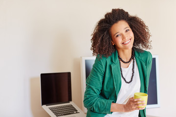 Businesswoman with curly hair holding a cup of coffee