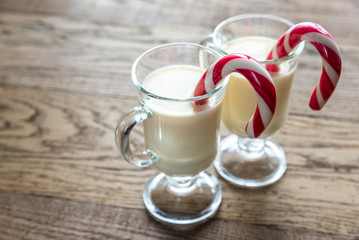 Two glasses of eggnog with mince pies
