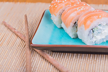 California maki sushi with fish and chopsticks