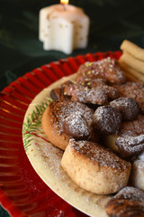 Christmas cookies with cup of black coffee decorated on a table with lighted candle
