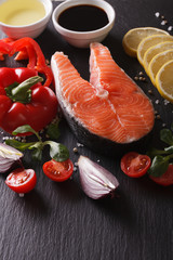 Raw salmon steak and ingredients on a board closeup. vertical
