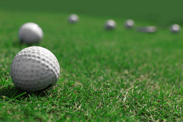 Golf balls on green field, close up