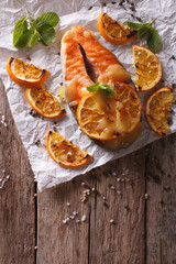 baked salmon with oranges on the table. vertical top view
