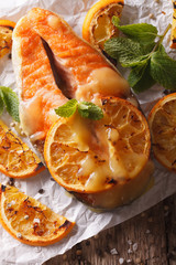 Naklejka na ściany i meble baked salmon with oranges close-up on the table. vertical top view 