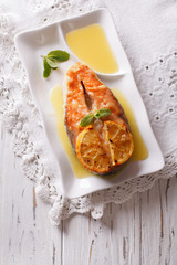 Gourmet Food: Baked salmon with orange on a plate. vertical top view
