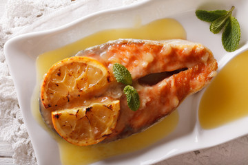 baked salmon steak with orange on a plate closeup. horizontal top view
