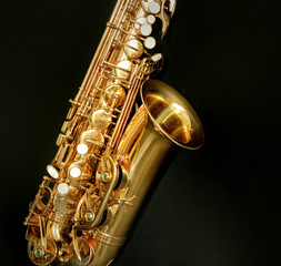 Obraz premium Beautiful golden saxophone on black background, close up