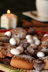 Christmas cookies with cup of black coffee decorated on a table with lighted candle