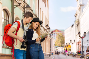 Young man and girl as two tourists with city map